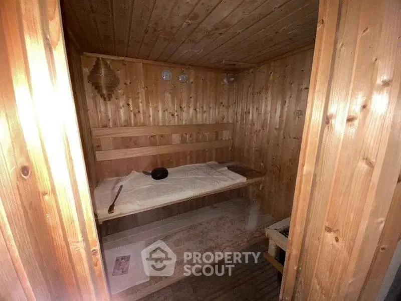Cozy wooden sauna room with bench seating and warm ambiance.