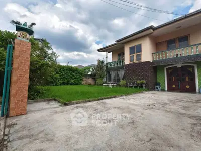 Charming two-story house with spacious driveway and lush garden, perfect for family living.