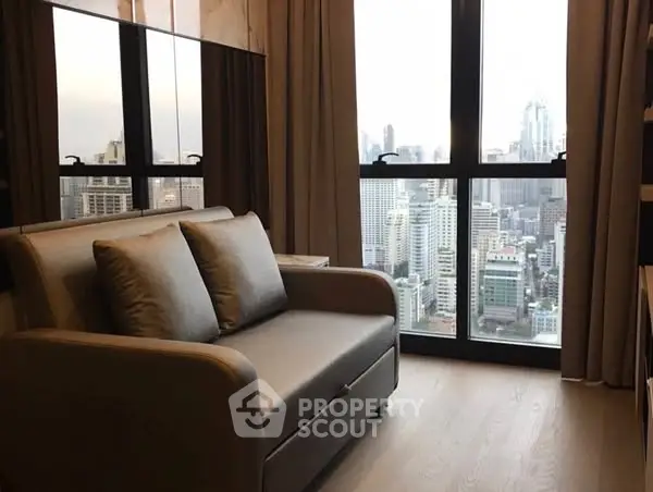 Modern living room with city view and cozy sofa in high-rise apartment.