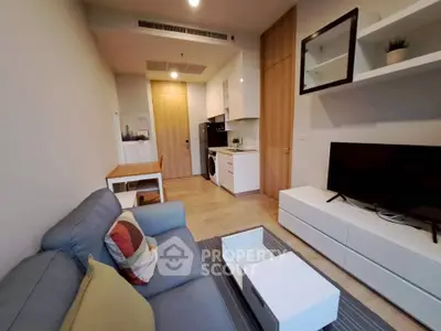 Modern living room with stylish furniture and open kitchen layout in a cozy apartment.