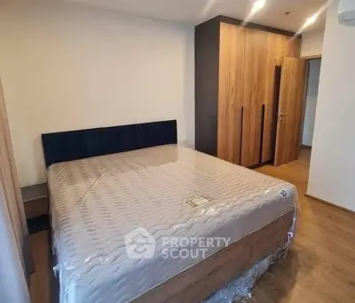 Spacious bedroom with modern wooden wardrobe and large bed in a stylish apartment.