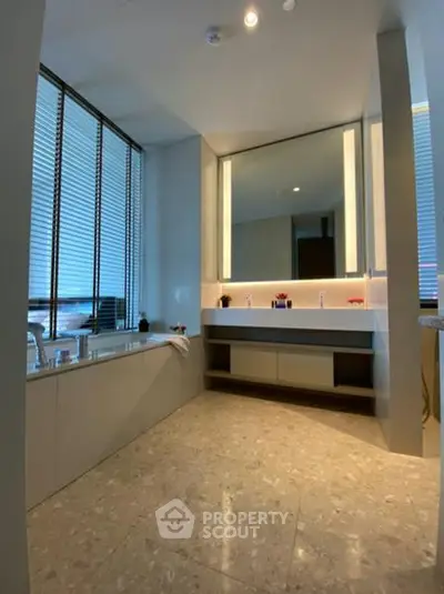 Luxurious modern bathroom with elegant fixtures and large mirror, featuring a spacious bathtub and sleek design.