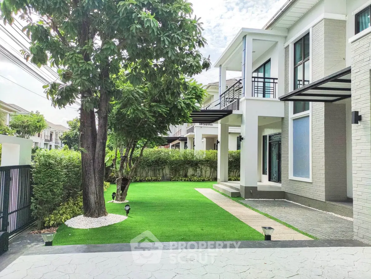 Luxurious modern home with lush green garden and elegant exterior design.