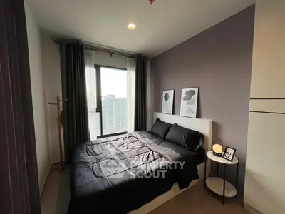 Modern bedroom with stylish decor and city view, featuring a cozy bed and elegant artwork.