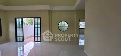 Spacious modern living room with large windows and glossy floors