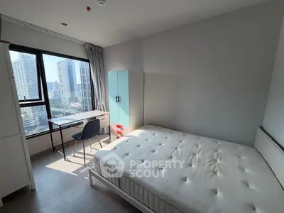 Modern bedroom with city view, featuring a cozy bed, desk, and wardrobe in a bright, airy space.
