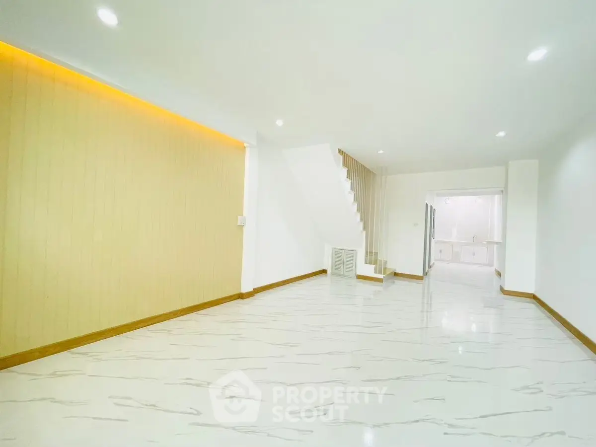 Spacious modern living room with elegant flooring and staircase
