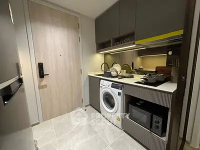 Modern compact kitchen with washing machine and microwave in stylish apartment