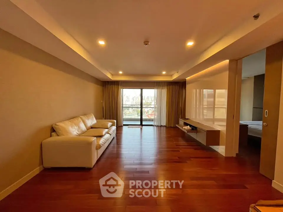 Spacious living room with hardwood floors and large windows for natural light.