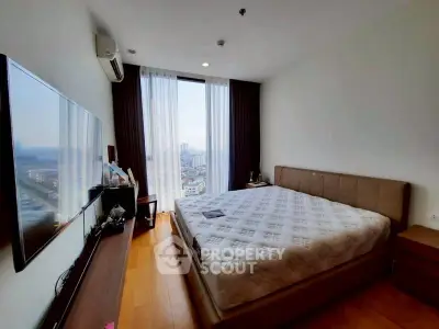 Spacious bedroom with city view, modern furnishings, and natural light.