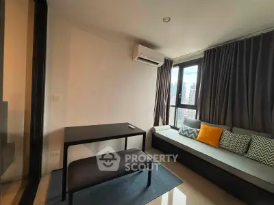 Modern living room with city view, featuring sleek furniture and large windows for natural light.