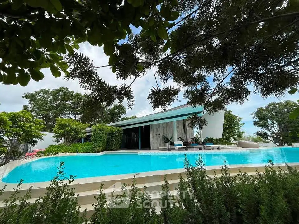 Luxurious modern villa with stunning pool and lush greenery, perfect for serene living.