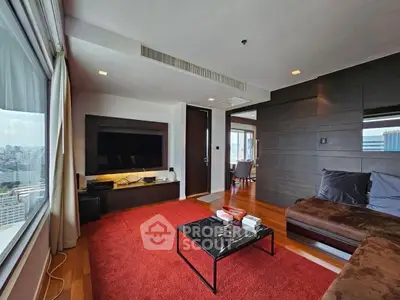 Spacious living room with city view, modern furniture, and warm wooden flooring.