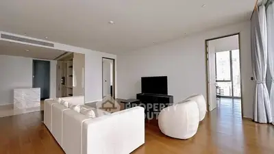Spacious modern living room with elegant white furniture and large windows.