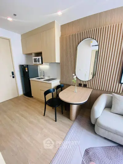 Modern studio apartment with stylish kitchen and cozy living area, featuring sleek furniture and elegant decor.