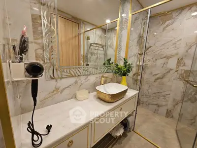 Luxurious bathroom with marble walls, gold accents, and modern fixtures