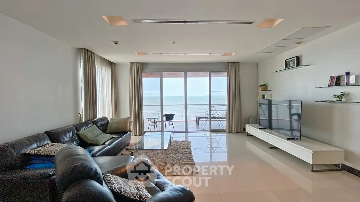 Spacious living room with ocean view, modern furniture, and large windows for natural light.