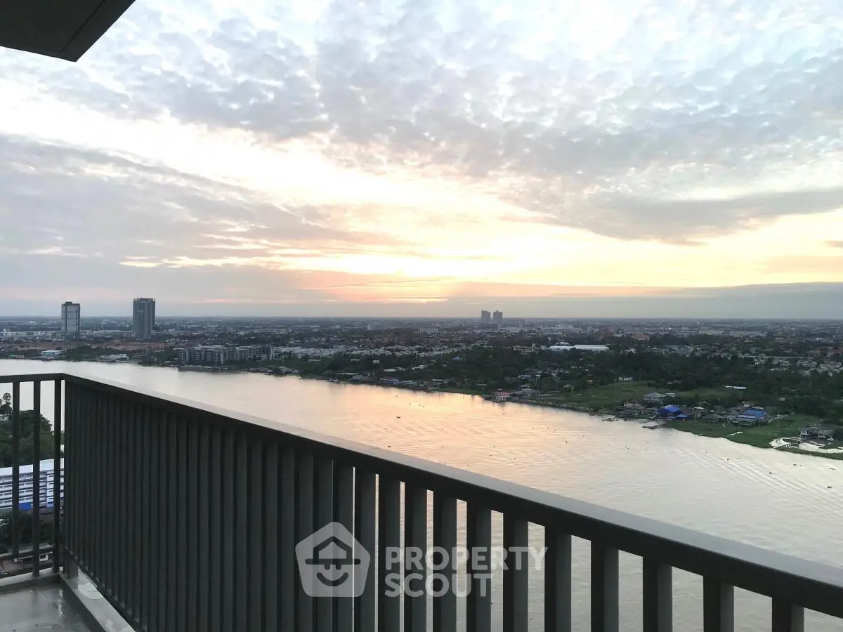 Stunning river view from high-rise balcony at sunset, perfect for serene living.