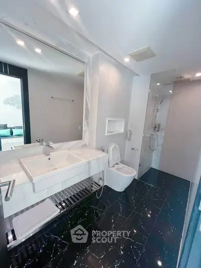 Luxurious modern bathroom with sleek marble finishes and spacious shower area.