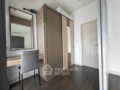 Modern bedroom with sleek wardrobe and stylish desk in a contemporary apartment.
