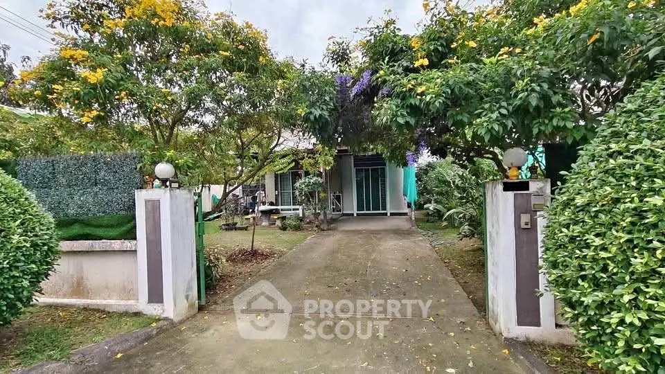 Charming garden entrance to a cozy home with lush greenery and inviting pathway.
