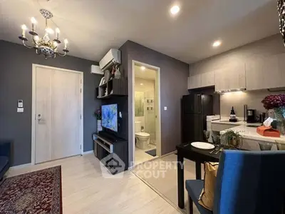 Modern open-plan living room with kitchen, featuring elegant decor and cozy ambiance.
