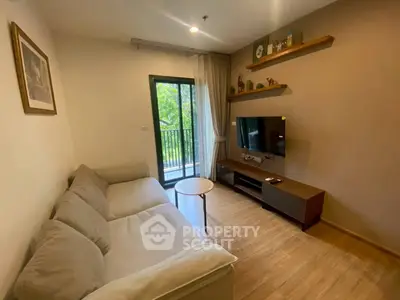 Cozy living room with modern decor and balcony view in a stylish apartment.