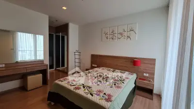 Spacious bedroom with floral decor and modern furnishings in a bright apartment.