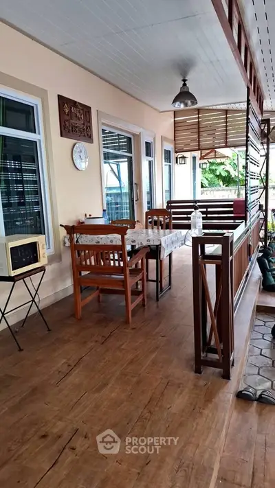 Charming wooden balcony with dining area and vintage decor, perfect for relaxing and entertaining.
