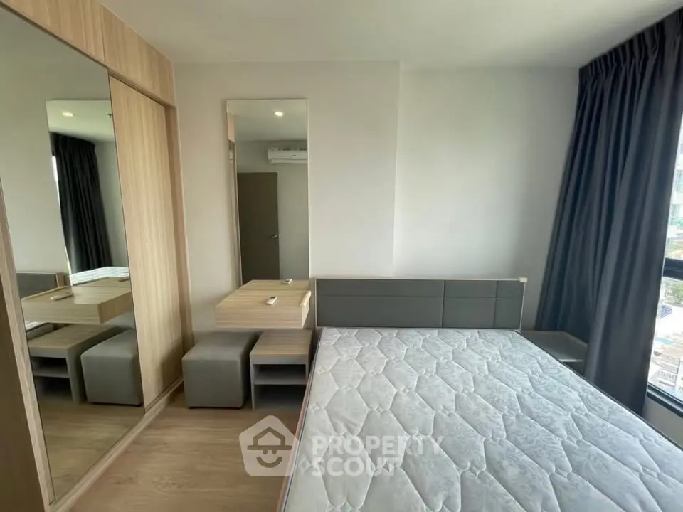 Modern bedroom with large window and stylish furniture in a high-rise apartment.