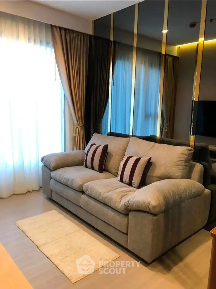 Cozy living room with plush sofa and elegant curtains in modern apartment.
