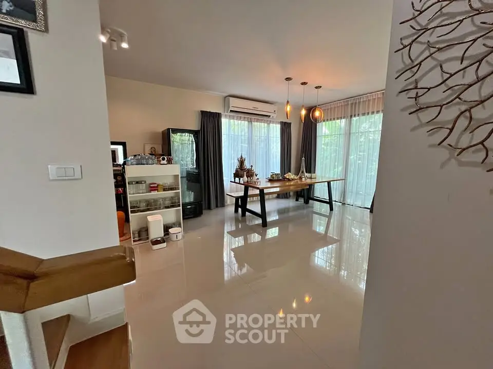 Spacious dining area with large windows and modern decor in a stylish home.