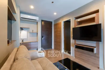 Modern living room with sleek design, wall-mounted TV, and cozy beige sofa.