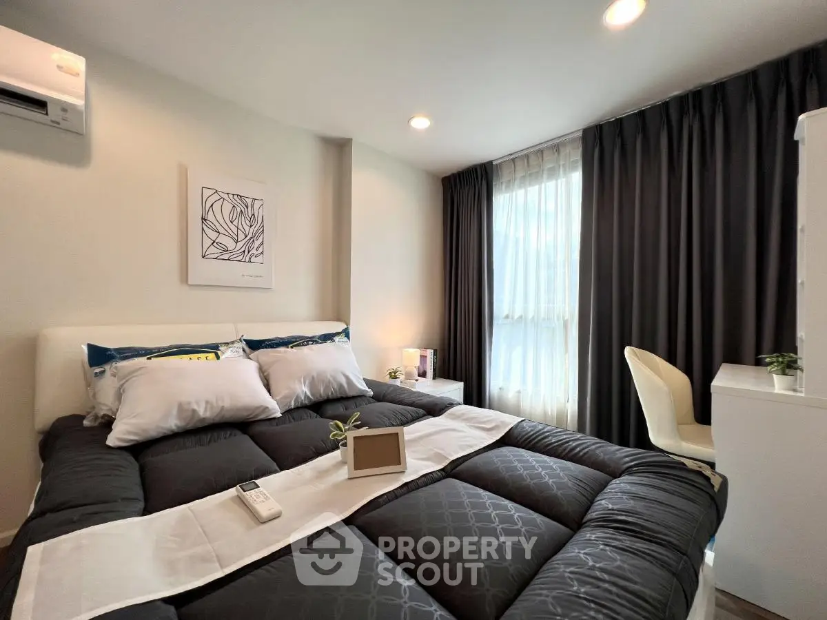 Modern bedroom with cozy bedding and natural light, perfect for relaxation.