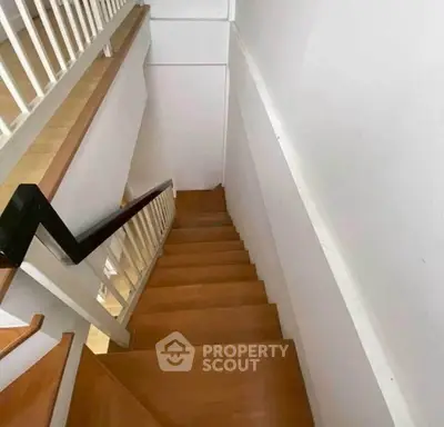 Modern wooden staircase with sleek railing in contemporary home interior