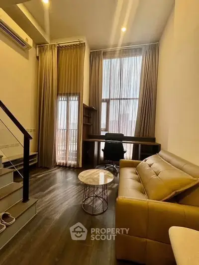 Modern living room with high ceilings, large windows, and stylish furniture in a contemporary apartment.