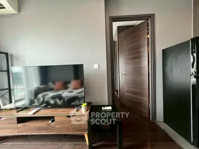 Modern living room with sleek TV stand and open door, showcasing contemporary design.