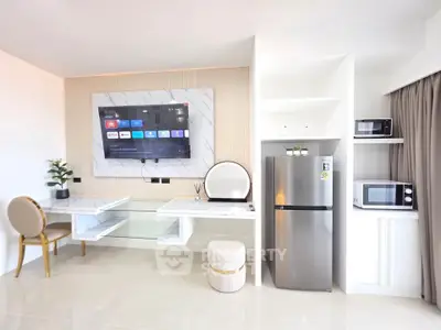 Modern living room with sleek furniture and built-in appliances, featuring a wall-mounted TV and stylish decor.