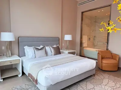 Luxurious bedroom with ensuite bathroom featuring a modern bathtub and elegant decor.