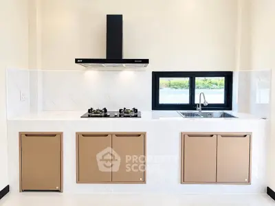 Modern kitchen with sleek cabinetry, gas stove, and stylish range hood in a bright, minimalist design.