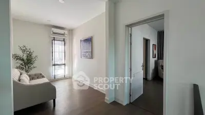 Modern living room with stylish decor and natural light, featuring a cozy sofa and elegant artwork.