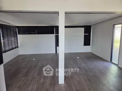 Spacious modern interior with sleek flooring and large windows, perfect for versatile living or office space.