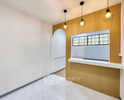 Modern kitchen with open layout and stylish lighting fixtures.