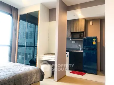 Modern studio apartment with compact kitchen and stylish bedroom