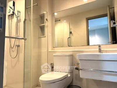 Modern bathroom with glass shower and sleek fixtures in a contemporary apartment.