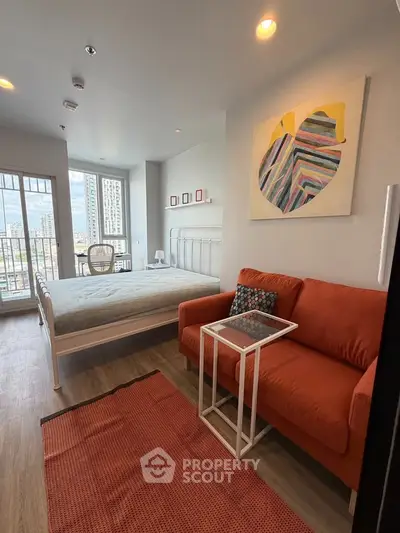Modern bedroom with city view, featuring cozy sofa and stylish decor in a high-rise apartment.