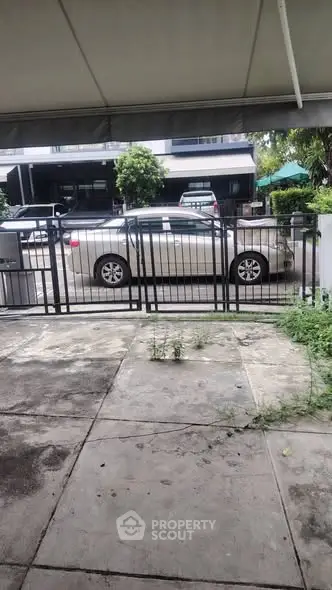 Spacious driveway with secure gate and street view, ideal for urban living.