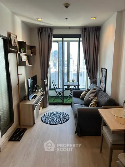 Modern living room with balcony view in high-rise apartment, featuring cozy sofa and stylish decor.