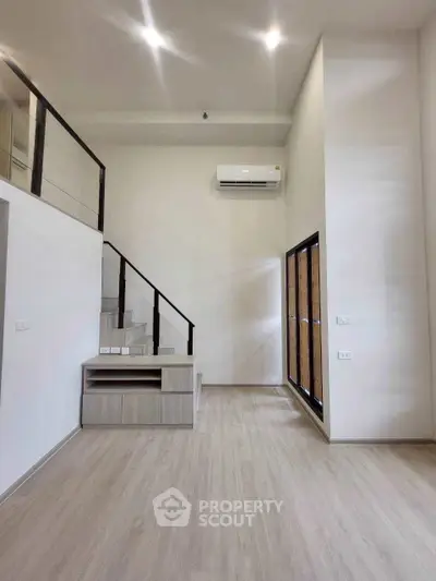 Modern minimalist living room with high ceiling and staircase