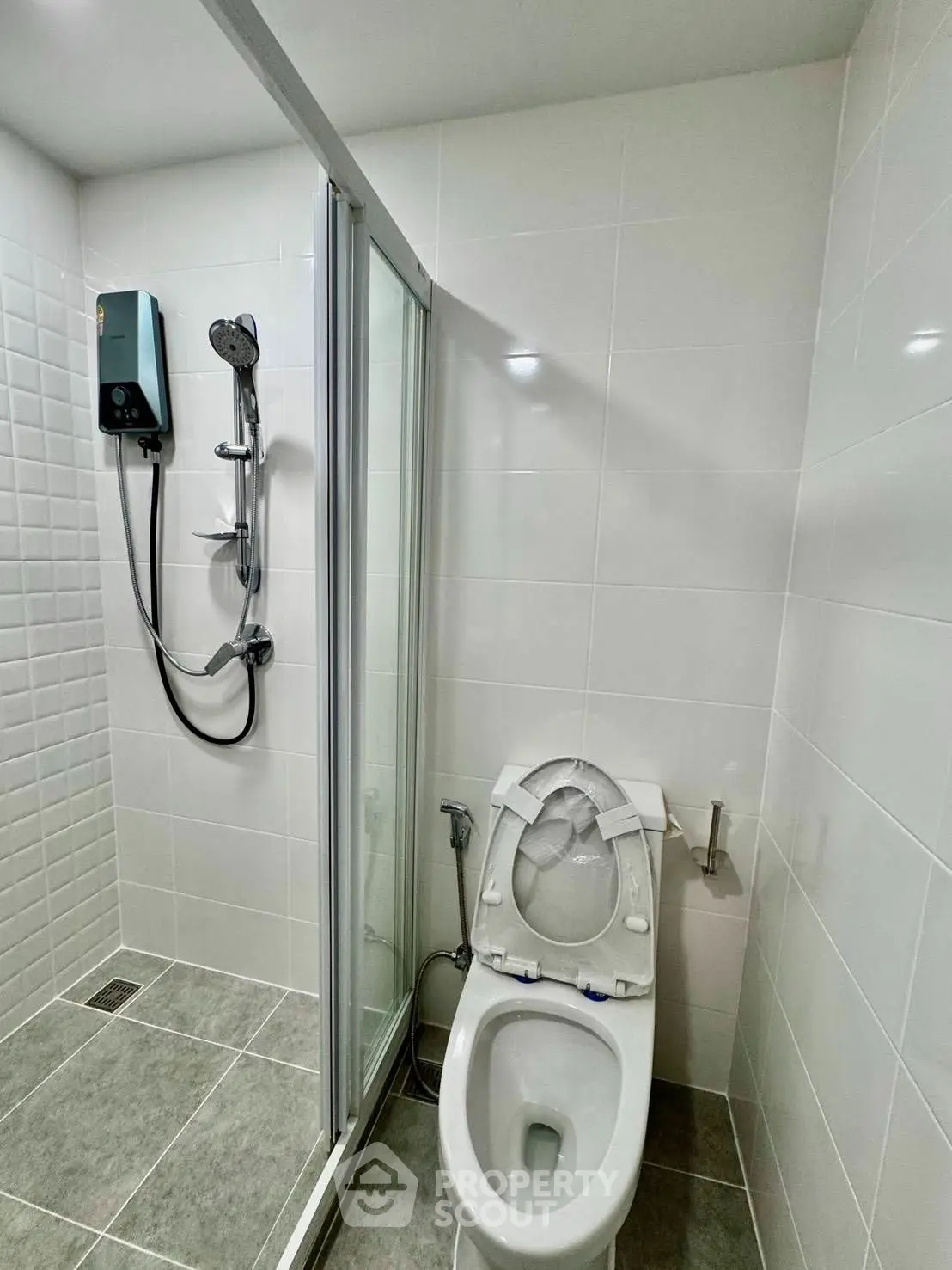 Modern bathroom with shower and toilet in sleek white tiles